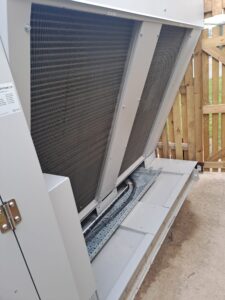Exterior of Clade Engineering's propane heat pump installed at Chelsham House, showing the large heat exchanger coils and piping infrastructure.